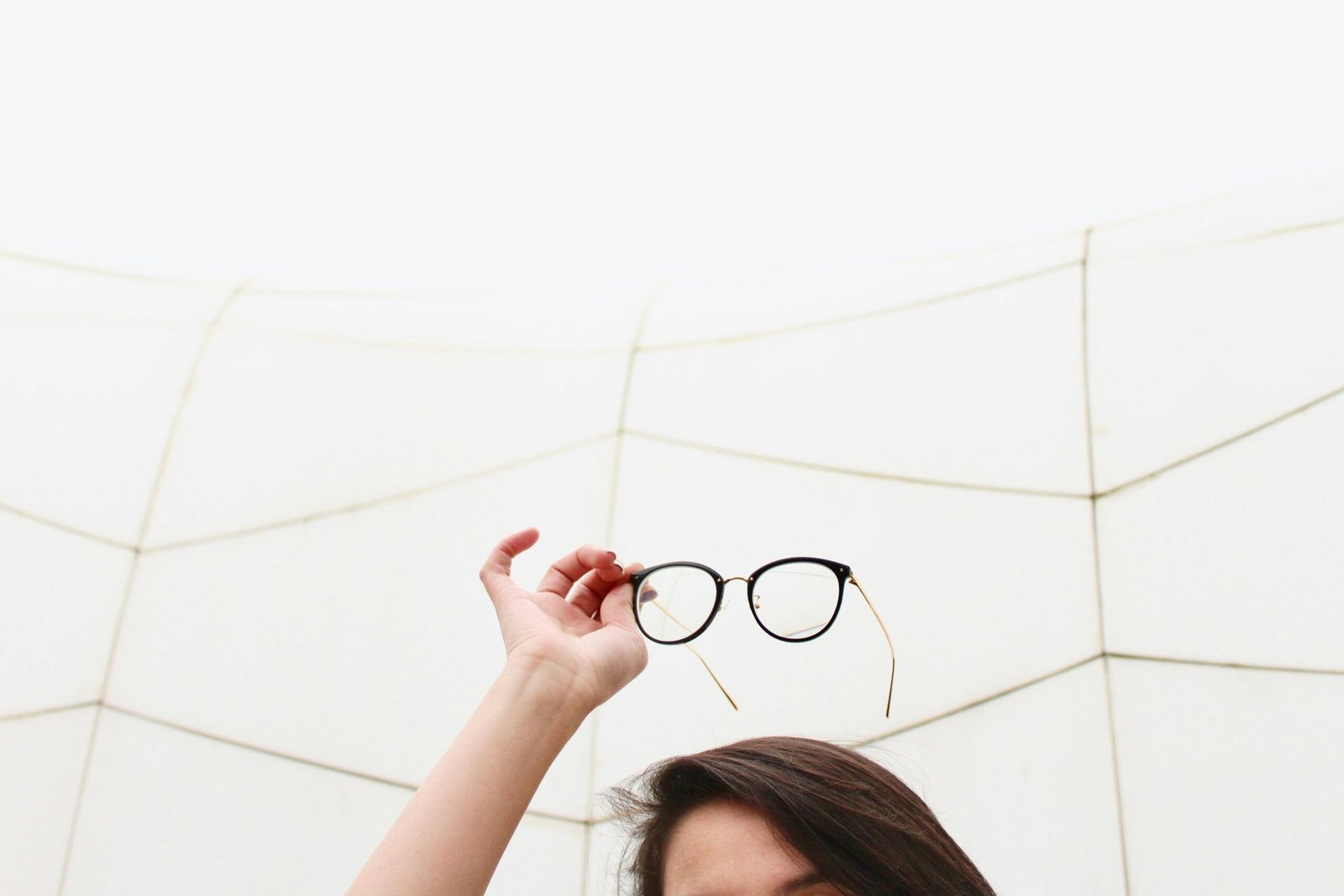 person holding black framed eyeglasses